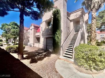 Condo exterior features classic stucco architecture and a stairway to the entrance at 5225 W Reno Ave # 219, Las Vegas, NV 89118