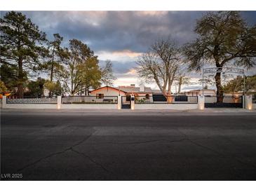 Beautiful exterior view of a home with a custom gate and manicured landscaping at 5700 N Torrey Pines Dr, Las Vegas, NV 89130
