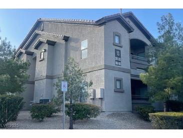 Neutral-toned apartment building featuring well-kept landscaping and clearly marked unit numbers at 8250 N Grand Canyon Dr # 2085, Las Vegas, NV 89166