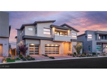 Stunning two-story home features a modern design, stone accents, a two-car garage and manicured landscaping at 10655 Patina Hills Ct, Las Vegas, NV 89135