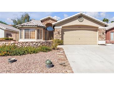 Charming home featuring a stone facade, two-car garage, and drought resistant landscaping at 1713 Diamond Oaks Ct, Las Vegas, NV 89117