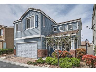 Charming two-story home with blue siding, brick accents, and a well-maintained front yard at 7633 Alexander Hills St, Las Vegas, NV 89139