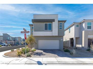 Contemporary two-story home featuring a brick driveway and a neutral-colored exterior, situated in a modern neighborhood at 10165 Canyon Mantle St, Las Vegas, NV 89166