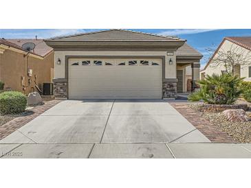 This home boasts a spacious garage with a concrete driveway, and desert landscaping at 2409 Garganey Ave, North Las Vegas, NV 89084