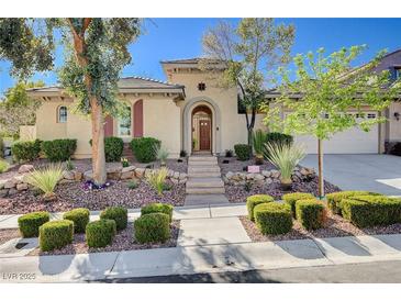 Charming single-story home featuring a landscaped front yard with stone accents and a welcoming arched entryway at 3663 Coventry Gardens Dr, Las Vegas, NV 89135