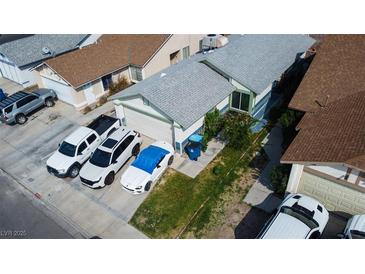 Aerial view of a single-Gathering home with a gray roof, a driveway, and a lush green lawn at 4432 Faberge Ave, Las Vegas, NV 89115