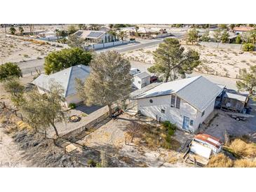 Wide aerial shot of a property with two houses, trees, and a large yard in a desert landscape at 4838 N Tioga Way, Las Vegas, NV 89149