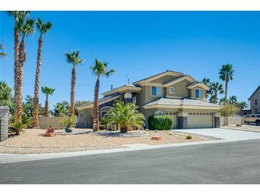 Inviting two-story home with desert landscaping, palm trees, and a three-car garage at 5640 Coe Estates Ct, Las Vegas, NV 89149