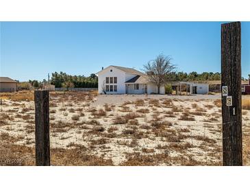 Charming two-story white home with a large yard and covered parking area at 861 Mcmurray Dr, Pahrump, NV 89060