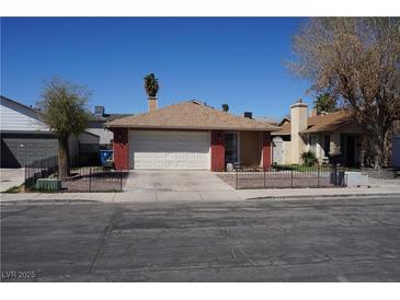 Single-story home with a two-car garage, brick accents, and a well-maintained front yard at 115 Parrish Ln, Las Vegas, NV 89110