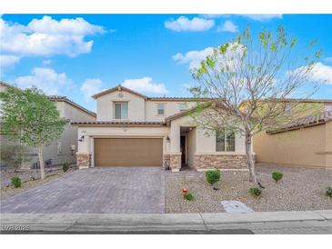 Charming two-story home with stone accents, a well-maintained yard, and a paved driveway at 1909 Pinsky Ln, North Las Vegas, NV 89032