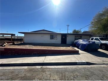 A single-story home with a front yard and a covered vehicle in the driveway under a bright, sunny sky at 3505 W Bonanza Rd, Las Vegas, NV 89107