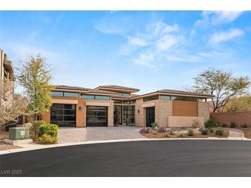 Contemporary desert home featuring desert landscaping, large windows and three car garage at 39 Cranberry Cove Ct, Las Vegas, NV 89135