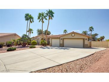Charming single-story home with palm trees and a large driveway leading to a two-car garage at 5217 Cold River Ave, Las Vegas, NV 89130