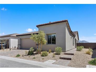 Stylish single-story home featuring desert landscaping, a two-car garage and a brick walkway under a clear blue sky at 10158 Super Jovian St, Las Vegas, NV 89143