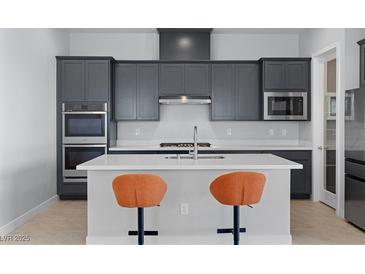 Modern kitchen features gray cabinetry, stainless steel appliances, and a center island with seating at 10158 Super Jovian St, Las Vegas, NV 89143