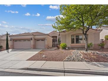 Charming single-story home featuring a well-manicured front yard with desert landscaping and a three-car garage at 10563 Sunblower Ave, Las Vegas, NV 89135
