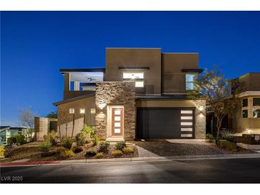 Modern two-story home featuring stone accents, an attached garage, and manicured landscaping at 1968 Regal Bluff Dr, Henderson, NV 89052