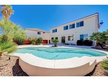 Backyard view showcases a sparkling pool, lush landscaping, and a well-maintained two-story house at 2726 Manteno Ct, Henderson, NV 89052