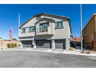 Modern townhome exterior features a balcony and three-car garages at 4790 Equinox Sky Ave # 2, North Las Vegas, NV 89084