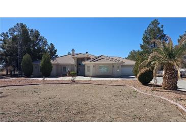 Spacious single-story home with a tile roof, circular driveway, and desert landscaping on a sunny day at 821 W Amarillo Ave, Pahrump, NV 89048