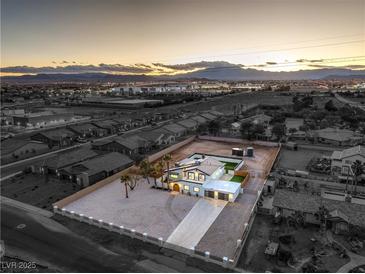 Expansive aerial view of a modern desert home showcasing the large lot and mountain views at sunset at 8645 Edmond St, Las Vegas, NV 89139