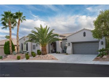 Charming single-story home boasts a well-manicured desert landscape, palm trees, and neutral color palette at 10261 Largo Sassetta Ct, Las Vegas, NV 89135