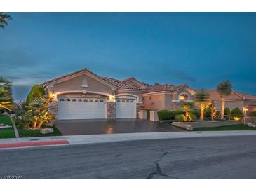 Charming single-story home featuring a three-car garage, desert landscaping, and a classic stucco facade at dusk at 10524 Longwood Dr, Las Vegas, NV 89134