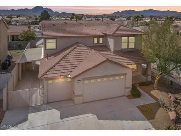 Two-story home featuring a three car garage, well-maintained landscaping, and a beautiful desert sunset backdrop at 1109 Pincay Dr, Henderson, NV 89015