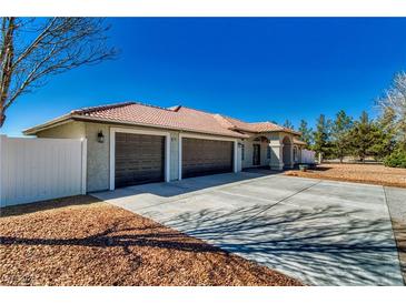 Charming single-story home featuring a spacious driveway and a well-maintained exterior with a three-car garage at 1131 China St, Pahrump, NV 89048