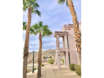 Building exterior with palm trees, sidewalks, and lovely mountain views on a sunny day at 1964 Las Palmas Ln # 244, Laughlin, NV 89029