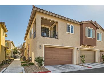 Charming townhome with a private balcony, a brown garage door, and a well-maintained front yard at 25 Barbara Ln # 38, Las Vegas, NV 89183