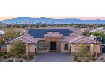 Beautiful single-story home featuring desert landscaping, solar panels, a brick driveway, and views of the Las Vegas skyline at 274 Chartan Ave, Las Vegas, NV 89183