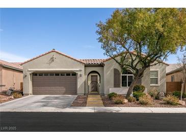 Charming single-story home featuring a well-manicured lawn, arched entryway, and a two-car garage at 3920 Eiderdown Pl, North Las Vegas, NV 89084