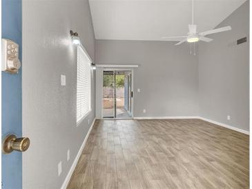 Bright living room with wood floors, sliding door to backyard, and a ceiling fan at 537 Inness Ave, Henderson, NV 89011