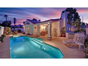 Stunning backyard pool with outdoor kitchen and covered patio, perfect for entertaining at 7405 Blue Sage Ct, Las Vegas, NV 89129