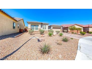 Charming home featuring desert landscaping, a two-car garage, and a neutral color scheme under a bright blue sky at 1012 Terron Allen Ave, North Las Vegas, NV 89031