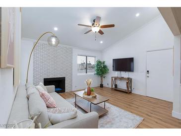 Bright living room featuring a ceiling fan, modern decor, and a decorative fireplace at 1701 E Katie Ave # 68, Las Vegas, NV 89119