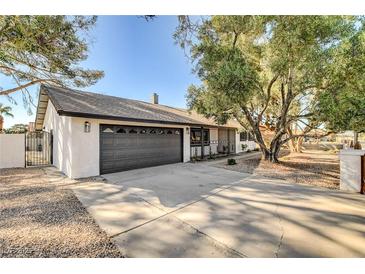 Charming single-story home with a well-manicured front yard and a gray two car garage at 2381 Marion St, Las Vegas, NV 89104