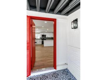 Inviting entryway featuring a red door, black and white patterned tile, and a glimpse into the updated kitchen at 3212 Hickey Ave, North Las Vegas, NV 89030