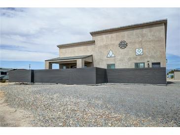 View of the home with a metal fence offering privacy and unique exterior design elements at 4830 E Comanche Dr, Pahrump, NV 89061