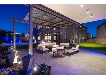 Outdoor patio with modern pergola, fire pit, and comfortable seating, perfect for evening relaxation and entertaining at 5231 Iron River Ct, Las Vegas, NV 89135