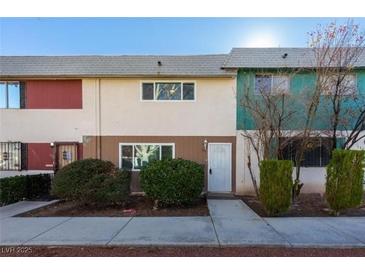 Inviting townhome with unique exterior color accents and well-maintained front landscaping at 135 Greenbriar Townhouse Way, Las Vegas, NV 89121