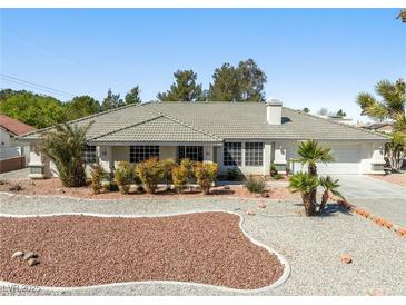 Charming single-story home featuring desert landscaping and a neutral color palette exterior at 2040 Tucuman Ave, Pahrump, NV 89048
