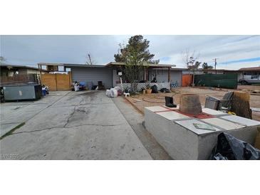 Modest single-story home featuring a covered porch and spacious front yard at 2125 Flower Ave, North Las Vegas, NV 89030