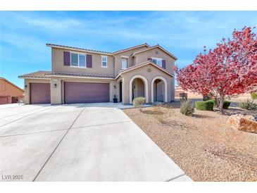 Two-story home featuring a large driveway, three-car garage and inviting arched entryway at 3809 Vincelli Ave, North Las Vegas, NV 89031