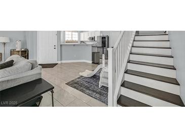 Inviting living area features tile flooring, light gray walls, and stairs to the second floor at 3920 Sweet Pine St # 102, Las Vegas, NV 89108