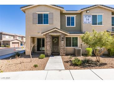 Inviting townhome entrance with stone accents, neutral tones, and xeriscaped front yard at 5730 Sky Pointe Dr # 165, Las Vegas, NV 89130