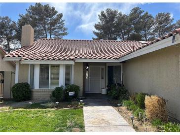 Charming front entrance features a tile roof, well-maintained landscaping and inviting walkway at 8641 Surtidor Dr, Las Vegas, NV 89117