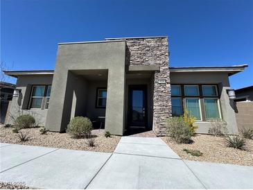 Modern home featuring a stacked stone accent wall and drought resistant landscaping at 928 Woodburn Ln, Las Vegas, NV 89138